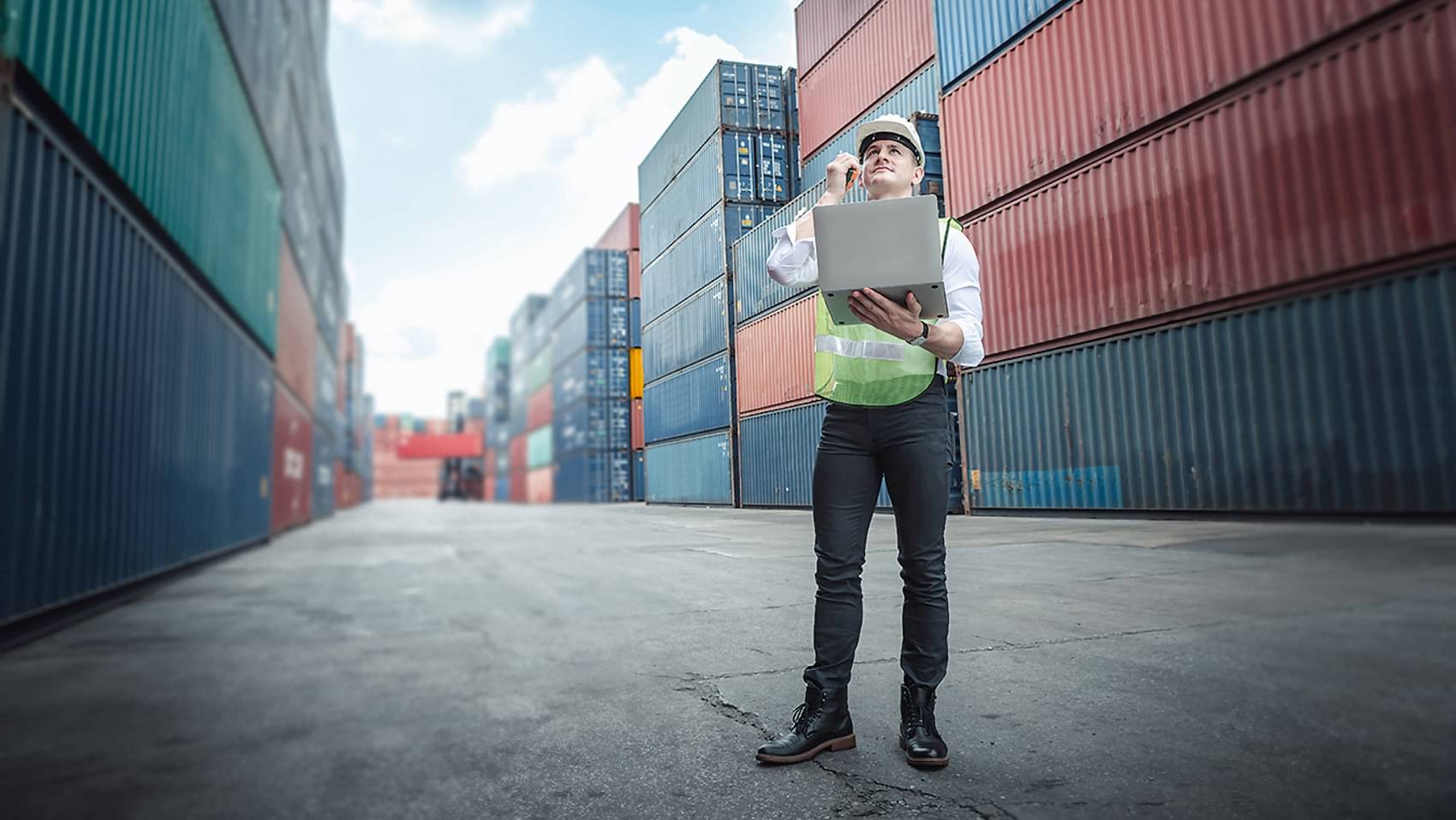 A transport engineer who manages the control of container placement via a laptop in a container yard.