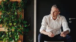 Businessman sitting in a green office. Sustainable banking.