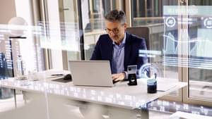 Businessman at the desk checks his banking transactions on the laptop, digital banking.